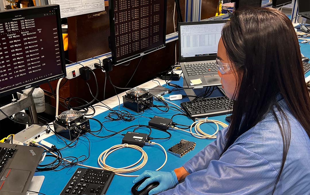 young electronics engineer performing speed tests at bench