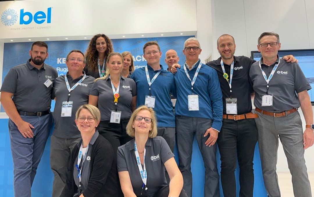 Bel associates gathering in front of a Bel event booth